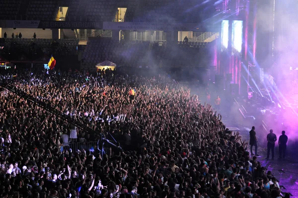 Multidão de pessoas com as mãos levantadas em um concerto — Fotografia de Stock