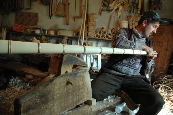 Carpenter handcrafting a wooden alpenhorn — Stock Photo, Image