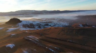 Gün batımında karlı kış tepelerinde uçarken hava manzarası