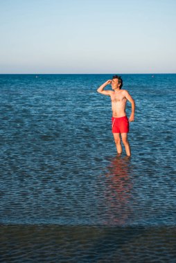 Deniz suyu kırmızı mayo poz ince adam. Parodi kavramı