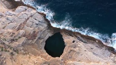 Yunanistan 'ın Thassos adasında, deniz kenarındaki doğal havuz olan Giola lagününün havadaki yavaş çekim görüntüsünün üzerinde