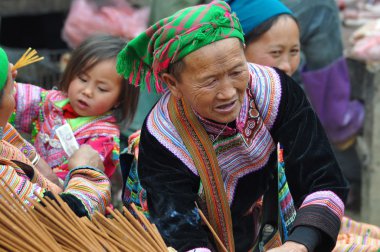 Vietnamese woman selling incense sticks in Bac Ha market, Vietna