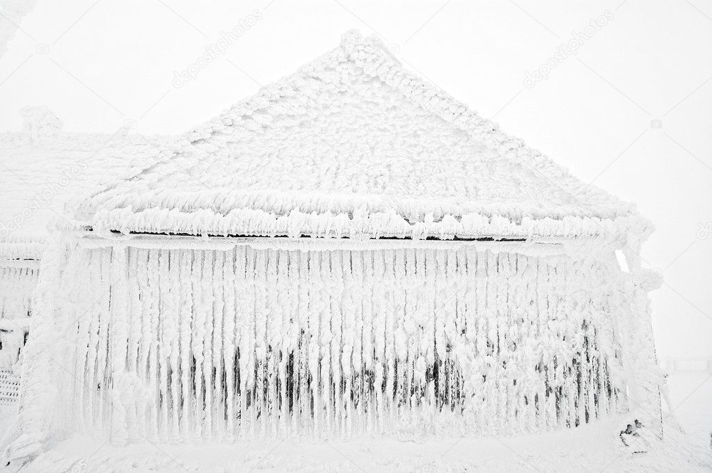 Snow and ice covered house after blizzard at winter