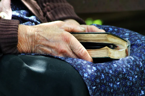 Mãos de ancião segurando a Bíblia Sagrada — Fotografia de Stock