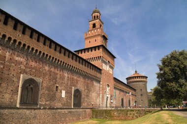 Milan, İtalya - 22 Ağustos 2021: Castello Sforzesco 'daki Filarete Kulesi, çevresindeki hendek, yeşil çimenlik ve ek savunma kuleleri görülebilir..