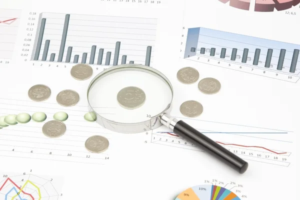 Business-stilleven van een diagram, Vergrootglas, munten — Stockfoto