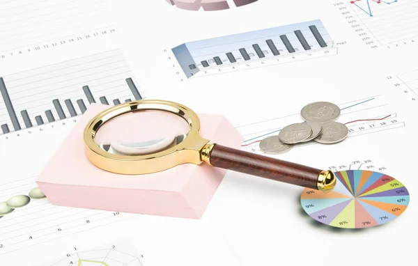 Business-stilleben av ett diagram, förstoringsglas, mynt, klistermärke — Stockfoto