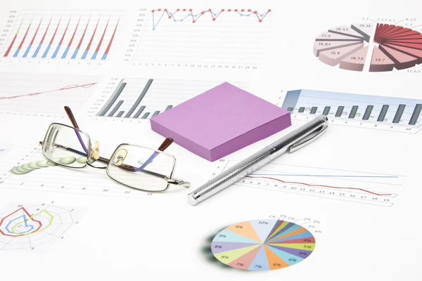 Business-stilleven van een pen, sticker, grafieken, brillen — Stockfoto