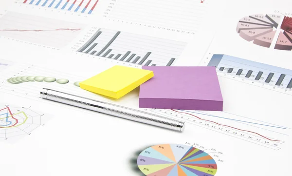Business-stilleven van glanzende pen, stickers, grafieken — Stockfoto