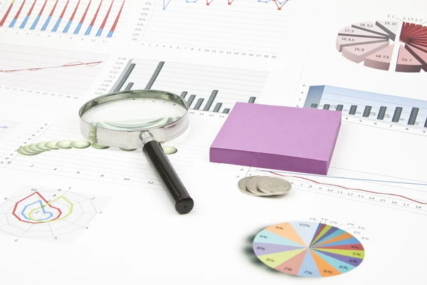 Business-stilleven van een diagram, Vergrootglas, munten, sticker — Stockfoto