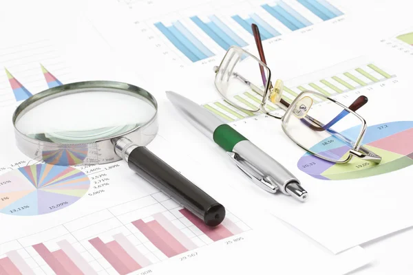 Business-stilleven van grafiek, brillen, Vergrootglas, glanzende pen — Stockfoto