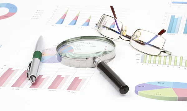 Business-stilleven van grafiek, brillen, Vergrootglas, glanzende pen — Stockfoto