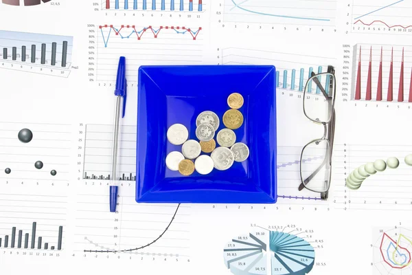 Bodegón de negocios de una pluma, anteojos, diagrama, monedas en un pl — Foto de Stock