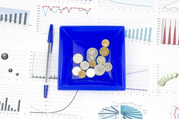 Business-stilleben av en penna, diagram, mynt i en tallrik — Stockfoto