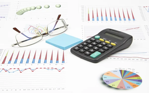Business-stilleven van een grafiek, brillen, sticker, rekenmachine — Stockfoto