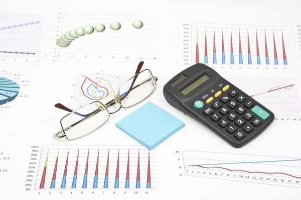 Natura morta aziendale di un grafico, occhiali, adesivo, calcolatrice — Foto Stock