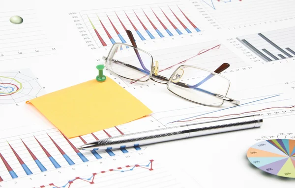 Business-stilleven van een pen, sticker, grafieken, brillen, punaise — Stockfoto
