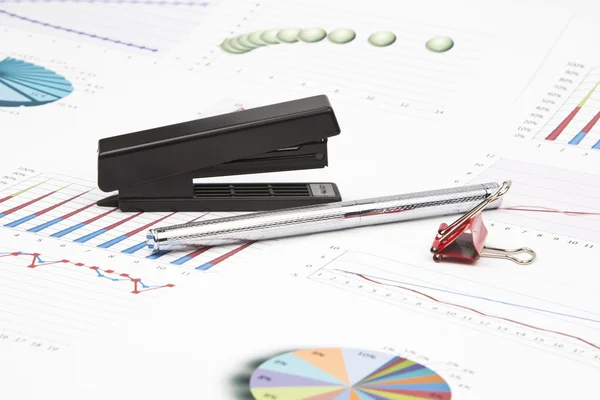 Business-stilleven van een grafieken, grafieken, paperclips, nietmachine — Stockfoto