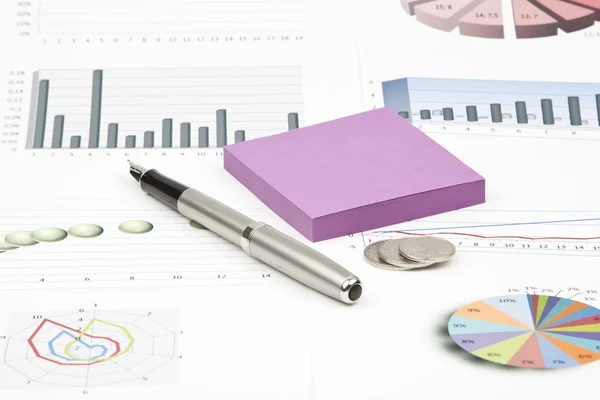 Business-stilleven van glanzende inkt pen, sticker, grafieken, munten — Stockfoto