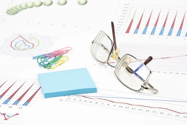 Business-stilleven van sticker, grafieken, brillen, paperclip — Stockfoto