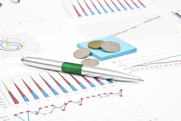 Bodegón de negocios de un bolígrafo verde, pegatina, gráficos, monedas — Foto de Stock