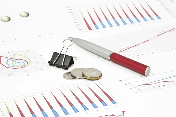 Business-stilleven van een pen, diagram, munten, paperclip — Stockfoto