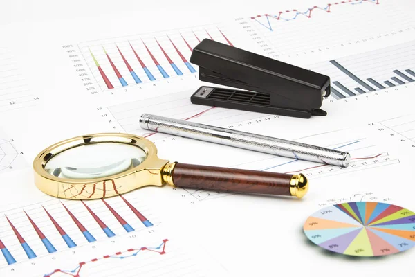 Business-stilleven van een grafieken, grafieken, pen, Vergrootglas, nietmachine — Stockfoto