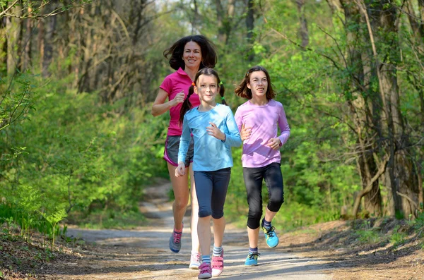 Desporto familiar, mãe ativa feliz e crianças correndo ao ar livre, correndo na floresta — Fotografia de Stock