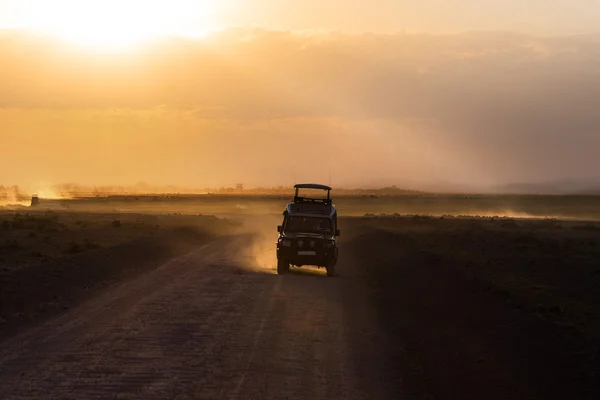 Ηλιοβασίλεμα στην αφρικανική σαβάνα, σιλουέτες των σαφάρι αυτοκίνητο και ζώα, την Αφρική, την Κένυα, Εθνικό Πάρκο Αμποσέλι — Φωτογραφία Αρχείου