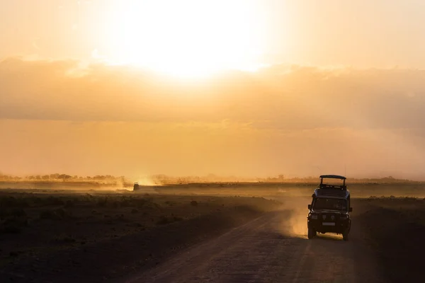 Solnedgång i Afrikansk savann, silhuetter av safari bil och djur, Afrika, Kenya, Amboseli national park — Stockfoto