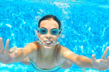 Çocuk havuzunda sualtı yüzüyor, mutlu kız gözlük içinde su altında eğlenir ve kabarcıklar, çocuk spor aile tatil yapar