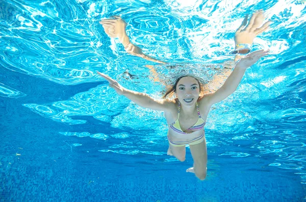 Niño nada en la piscina bajo el agua, chica se divierte bajo el agua, deporte infantil activo en vacaciones familiares —  Fotos de Stock