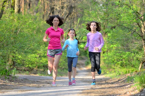 Aile spor, mutlu etkin anne ve açık havada jogging, ormanda koşu çocuklar — Stok fotoğraf
