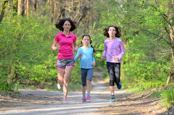 Familiesport, gelukkig actieve moeder en kinderen joggen buiten, die in bos loopt — Stockfoto