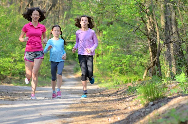Familjen sport, glada aktiva mor och barn jogga utomhus, med i skogen — Stockfoto