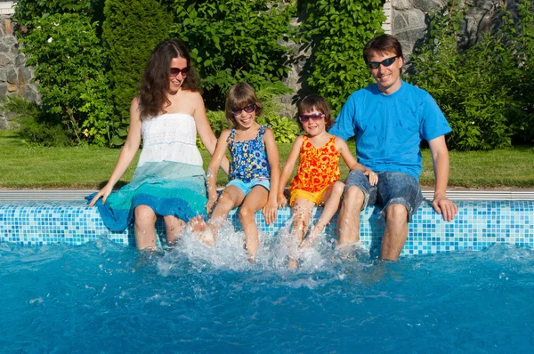 Famiglia felice con i bambini che si divertono vicino alla piscina in vacanza estiva — Foto Stock