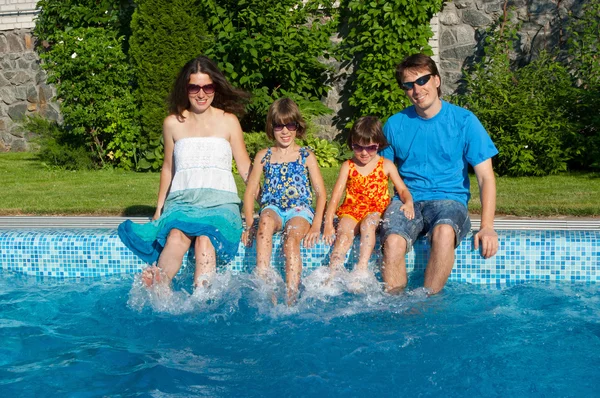 Lycklig familj med barn att ha kul nära pool på sommarlovet — Stockfoto