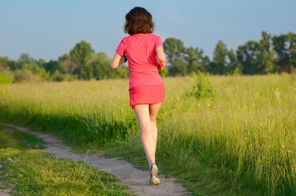 Vrouw runner joggen op trail buitenshuis, spring uitgevoerd en oefenen — Stockfoto