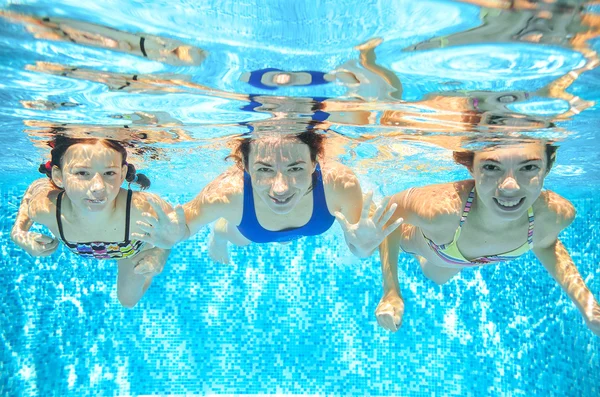 Family swims in pool under water, happy active mother and children have fun underwater, kids sport on family vacation — Stock Photo, Image