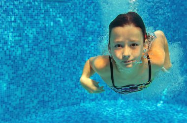 Çocuk havuzunda sualtı, etkin kız atlar, Dalış ve eğlenir, çocuk spor aile tatil mutlu yüzüyor