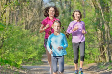 Aile spor, mutlu etkin anne ve açık havada jogging, ormanda koşu çocuklar