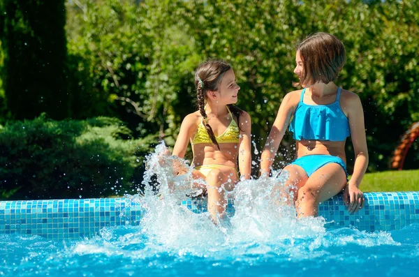 I bambini in piscina si divertono e schizzano in acqua, i bambini in vacanza in famiglia — Foto Stock