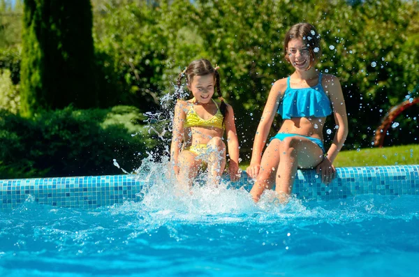 Fitness estivo, i bambini in piscina si divertono, le ragazze sorridenti schizzano in acqua, i bambini in vacanza in famiglia — Foto Stock