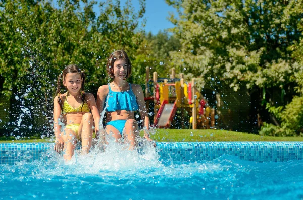 Летний фитнес, дети в бассейне веселятся, улыбающиеся девочки плещутся в воде, дети на семейном отдыхе — стоковое фото