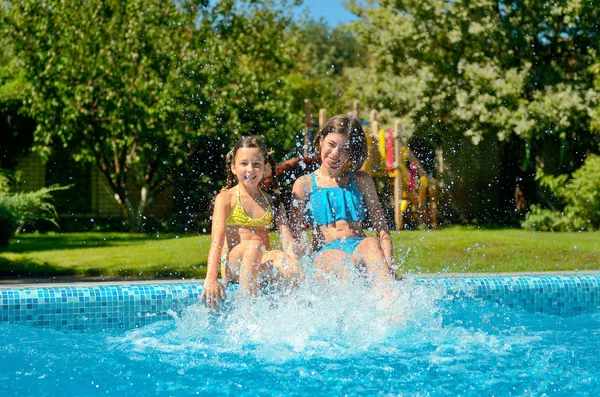 Barnen i poolen har kul och plaska i vatten, barn på familjesemester — Stockfoto