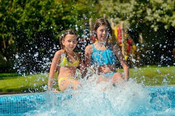 I bambini in piscina si divertono e schizzano in acqua, i bambini in vacanza in famiglia — Foto Stock