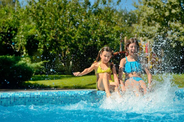 I bambini in piscina si divertono e schizzano in acqua, i bambini in vacanza in famiglia — Foto Stock