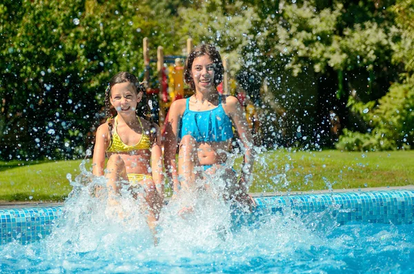 Kids in swimming pool have fun and splash in water, children on family vacation — Stock Photo, Image