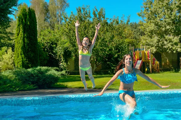 Kinderen springen naar zwembadwater en hebben leuke, gelukkig actieve kinderen op familievakantie — Stockfoto