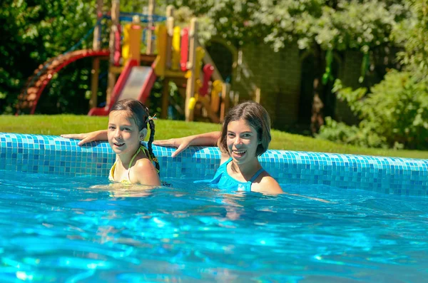 I bambini in piscina si divertono e schizzano in acqua, i bambini in vacanza in famiglia — Foto Stock